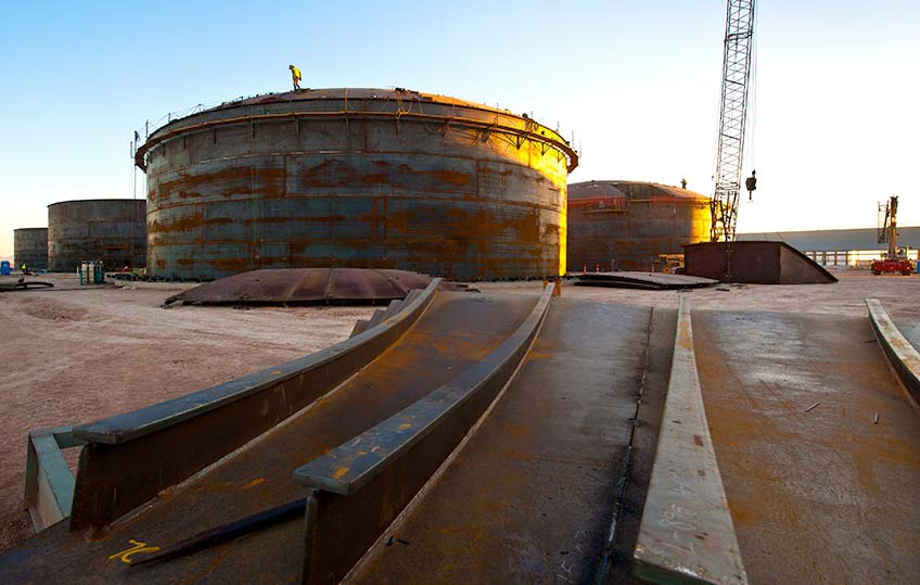 20099-720-thumb Sun sets on a group of large, circular tanks.